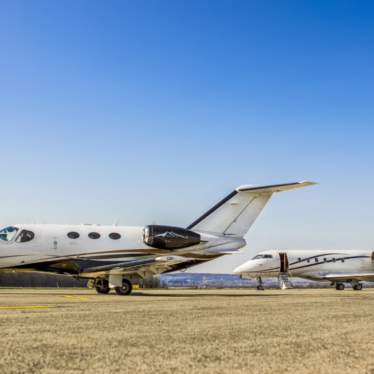 Two private jets parked on an airport apron.