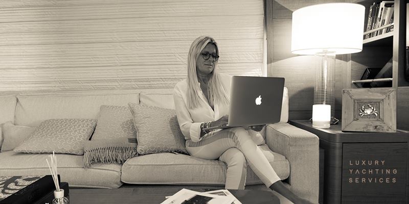 Sepia-toned portrait of Cinzia Bulciolu working on a laptop in a yacht saloon.