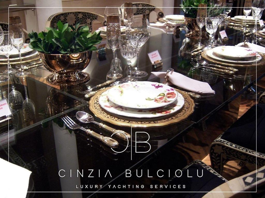Formal dining table laid with fine china and bronze centrepieces.